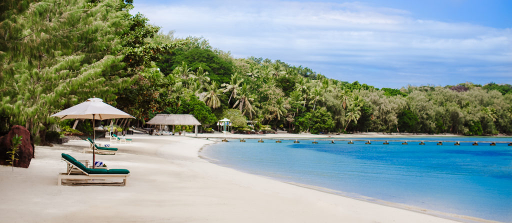 Beach resort on a tropical island in Fiji with white sand and clear blue water