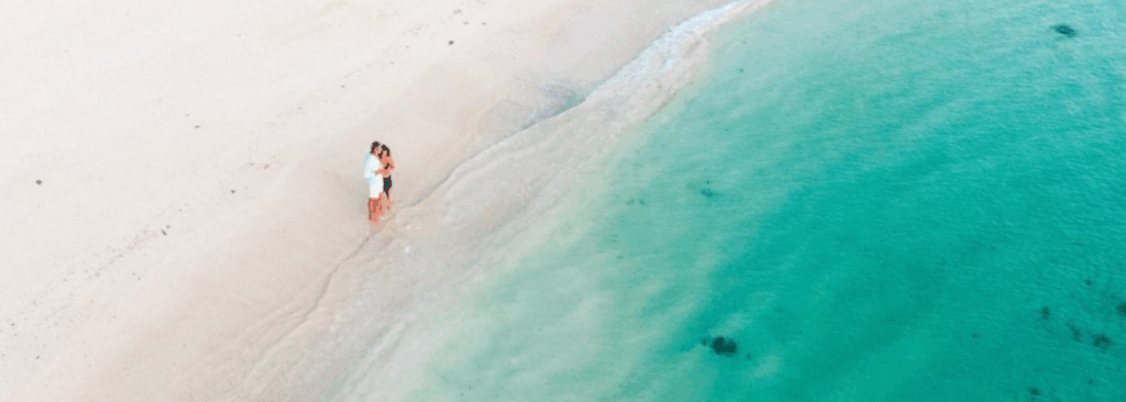 Couple on a paradise island in Fiji with white sand beach and turquoise waters