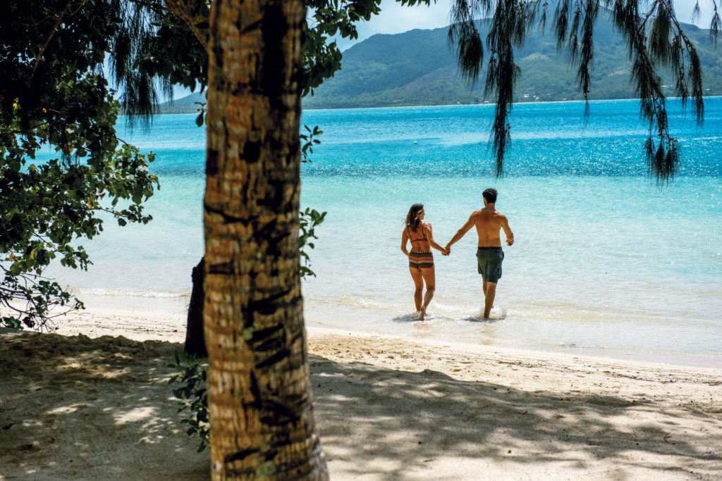 Couple on a paradise island in Fiji with white sand beach and turquoise waters