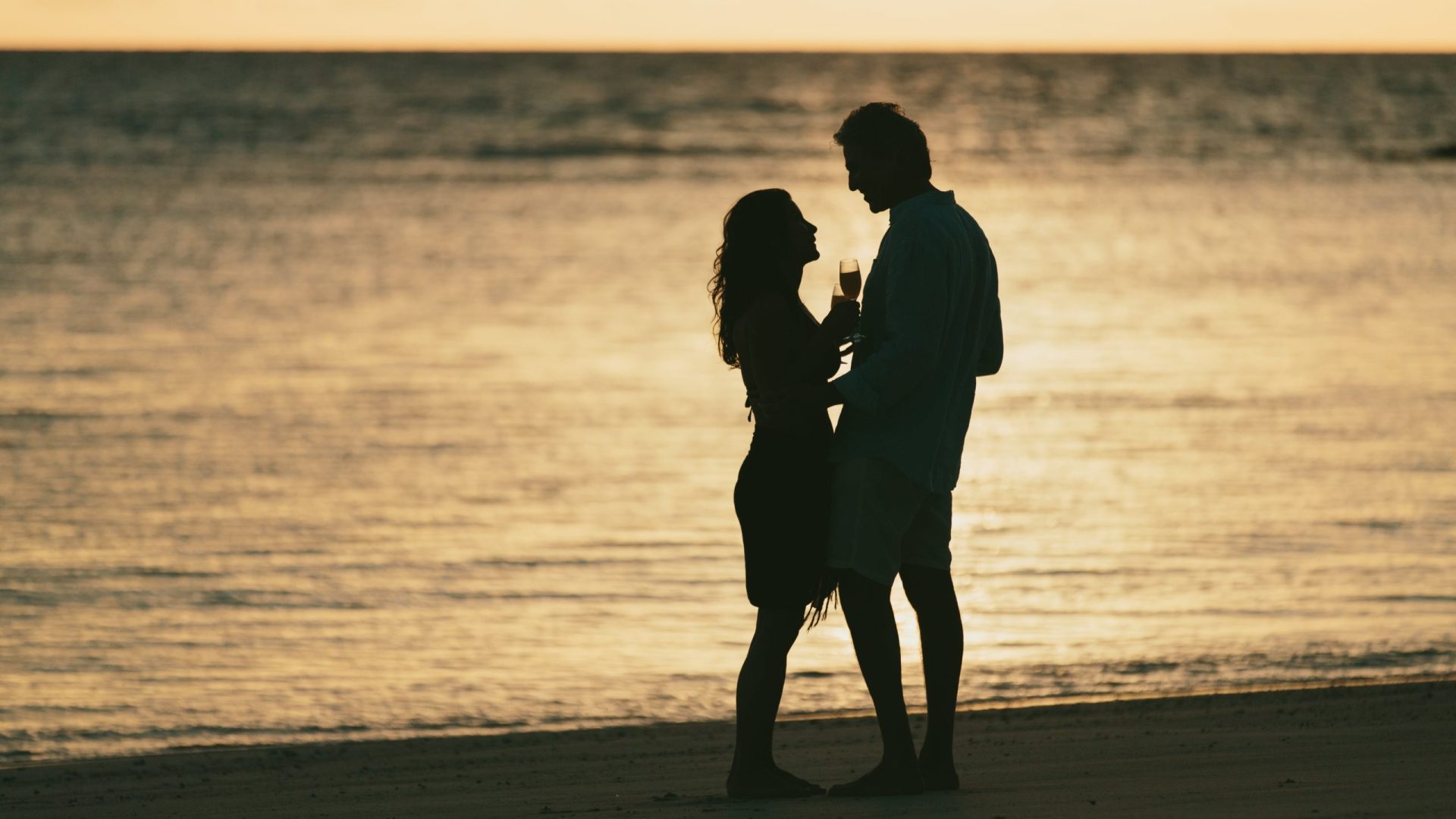 A honeymoon anniversary couple enjoying a romantic moment together in a beautiful tropical setting, celebrating their love and time together.